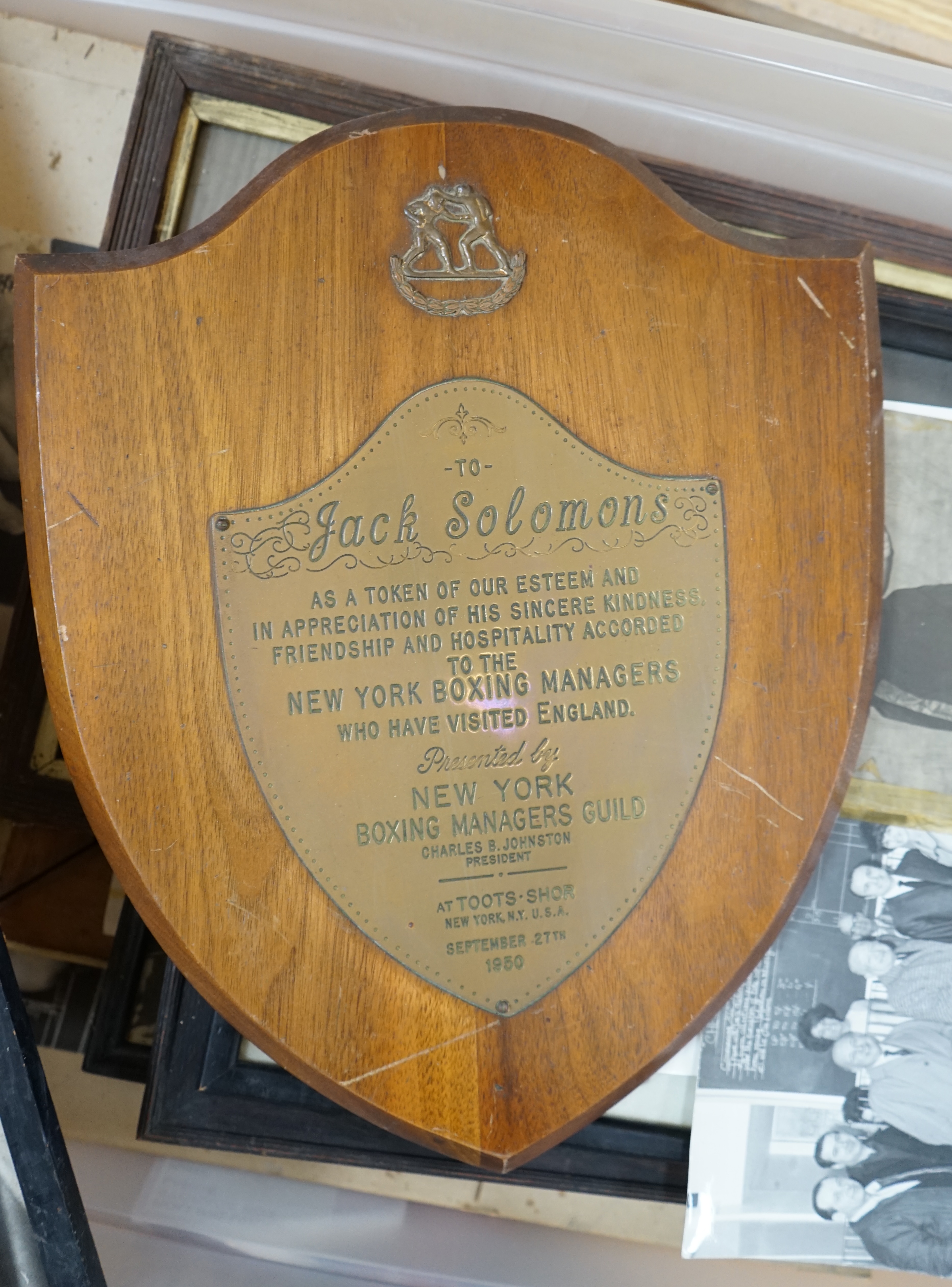 A collection of Jack Solomans boxing promo ephemera to include a shield shaped plaque, black and white photographs, books and a pastel portrait. Condition - varies